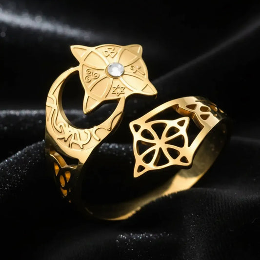 Gold Celtic knot crescent moon ring close-up, showing the engraved lunar band, star-shaped medallion set with a clear stone, and open quaternary knot cutout design.