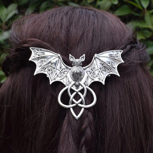 Silver Gothic Bat Hairpin with Celtic knot, a witchy Halloween barrette in dark brown braided hair.