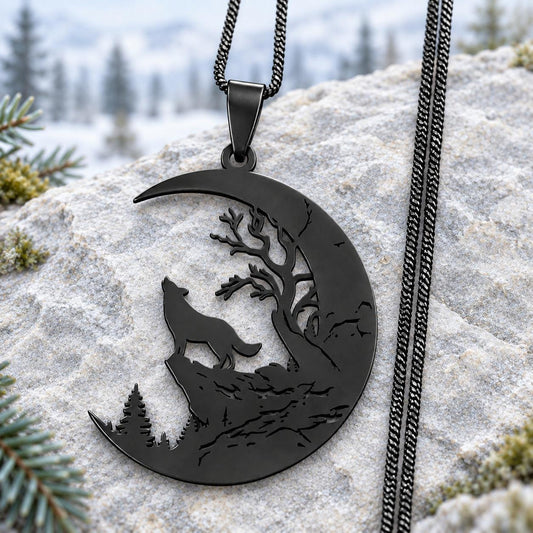 Black stainless steel Howling Wolf Crescent Moon Necklace with tree cutouts and black chain on pale stone with a soft woodland background.