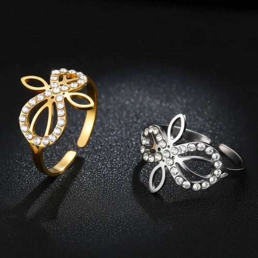 Gold and silver Infinity Celtic knot zircon rings standing side by side, showing the adjustable open-band design and sparkling stone details