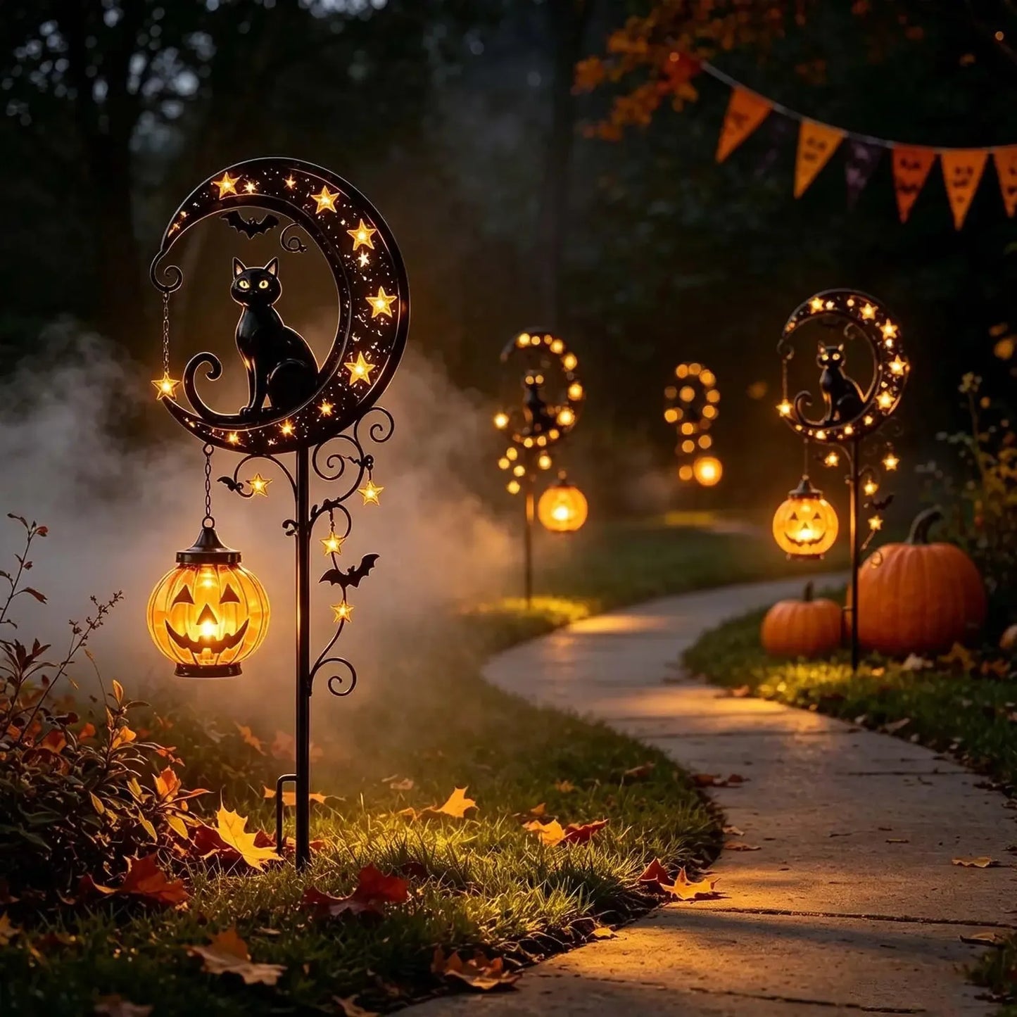 Black cat bat solar stake lights lining garden pathway at night with autumn leaves