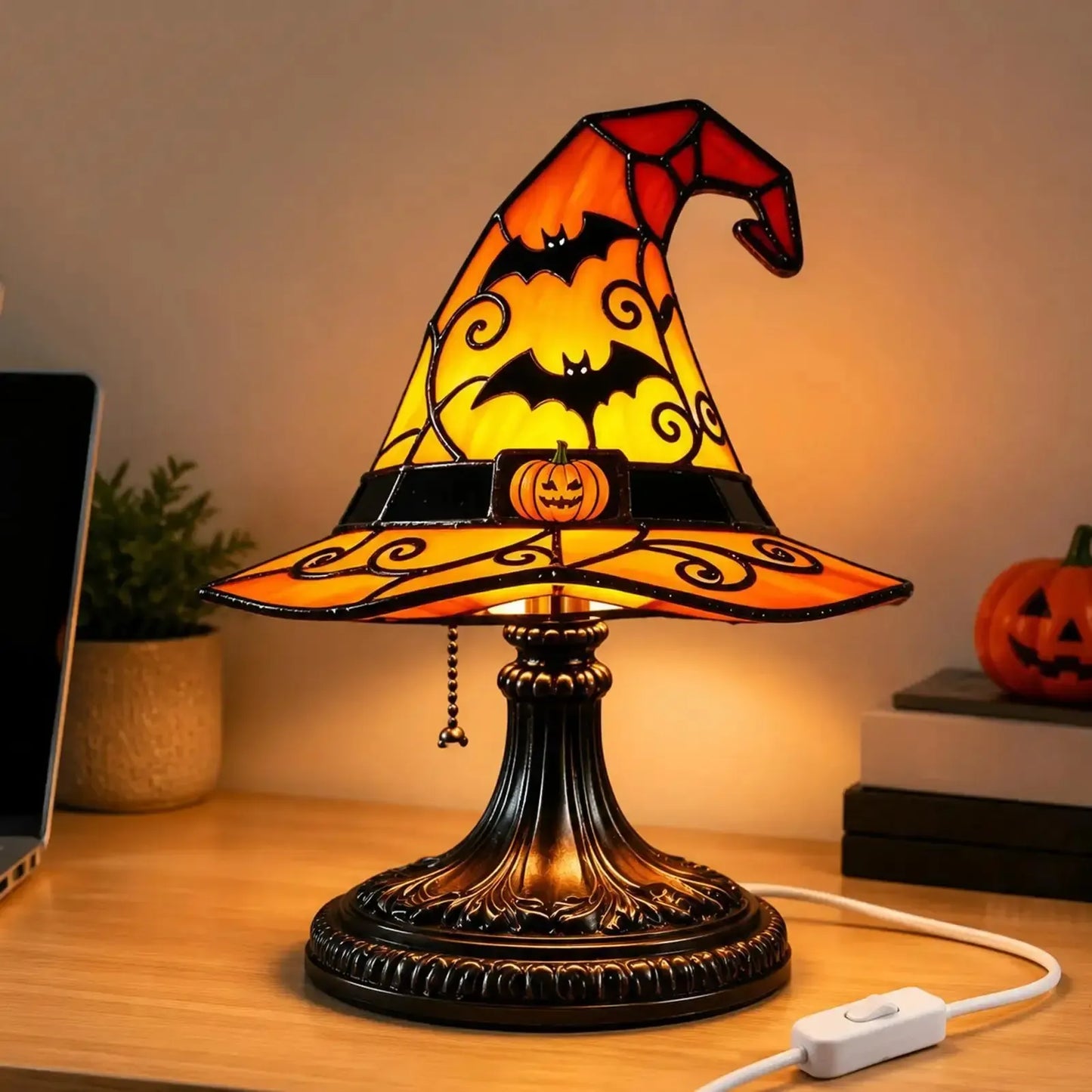 Witch hat table lamp on office desk with laptop plant and pumpkin decor
