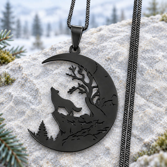 Black stainless steel Howling Wolf Crescent Moon Necklace with tree cutouts and black chain on pale stone with a soft woodland background.