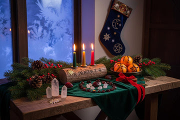 Pagan yule decorations with candles, crystals, oranges, and evergreen branches for a magical winter altar setup