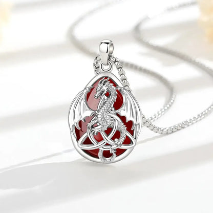 Carnelian Celtic dragon necklace arranged on a sunlit white display surface