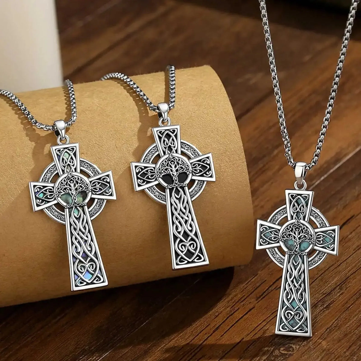 Three Celtic cross pendants displayed together