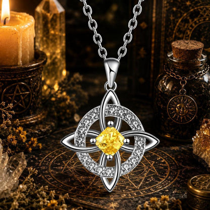 Celtic Witch Knot pendant necklace with yellow gemstone, witchcraft jewelry on altar with candle and crystals