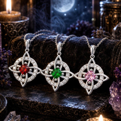 Celtic Witch Knot pendant necklaces with red, green, pink gems, crystal accents, on witchy altar with moon & candles