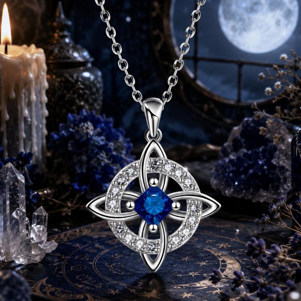 Celtic Witch Knot pendant necklace with blue gemstone, crystals, candle, and moon backdrop for witchcraft altar