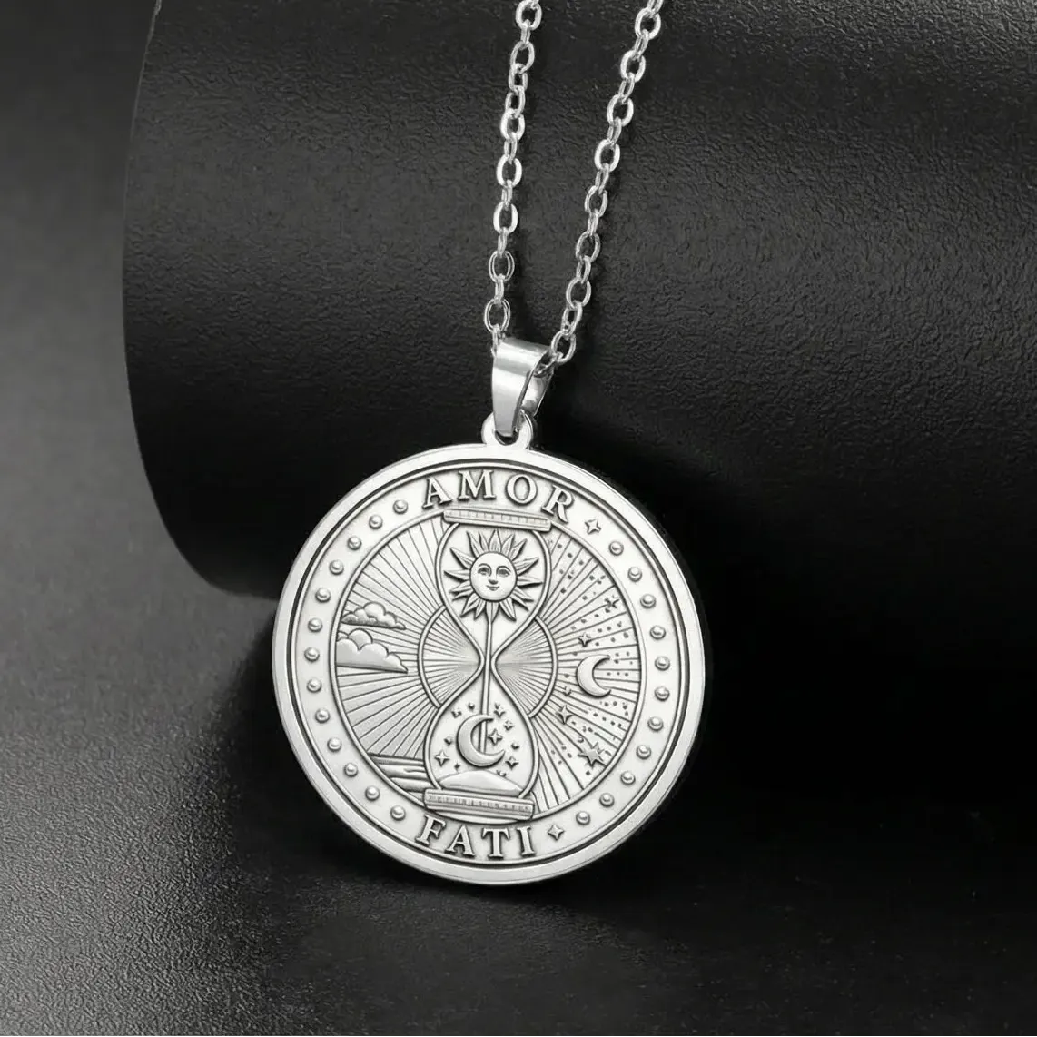 Silver-tone Amor Fati necklace on a display stand