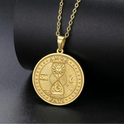 Gold-tone Amor Fati necklace on a display stand