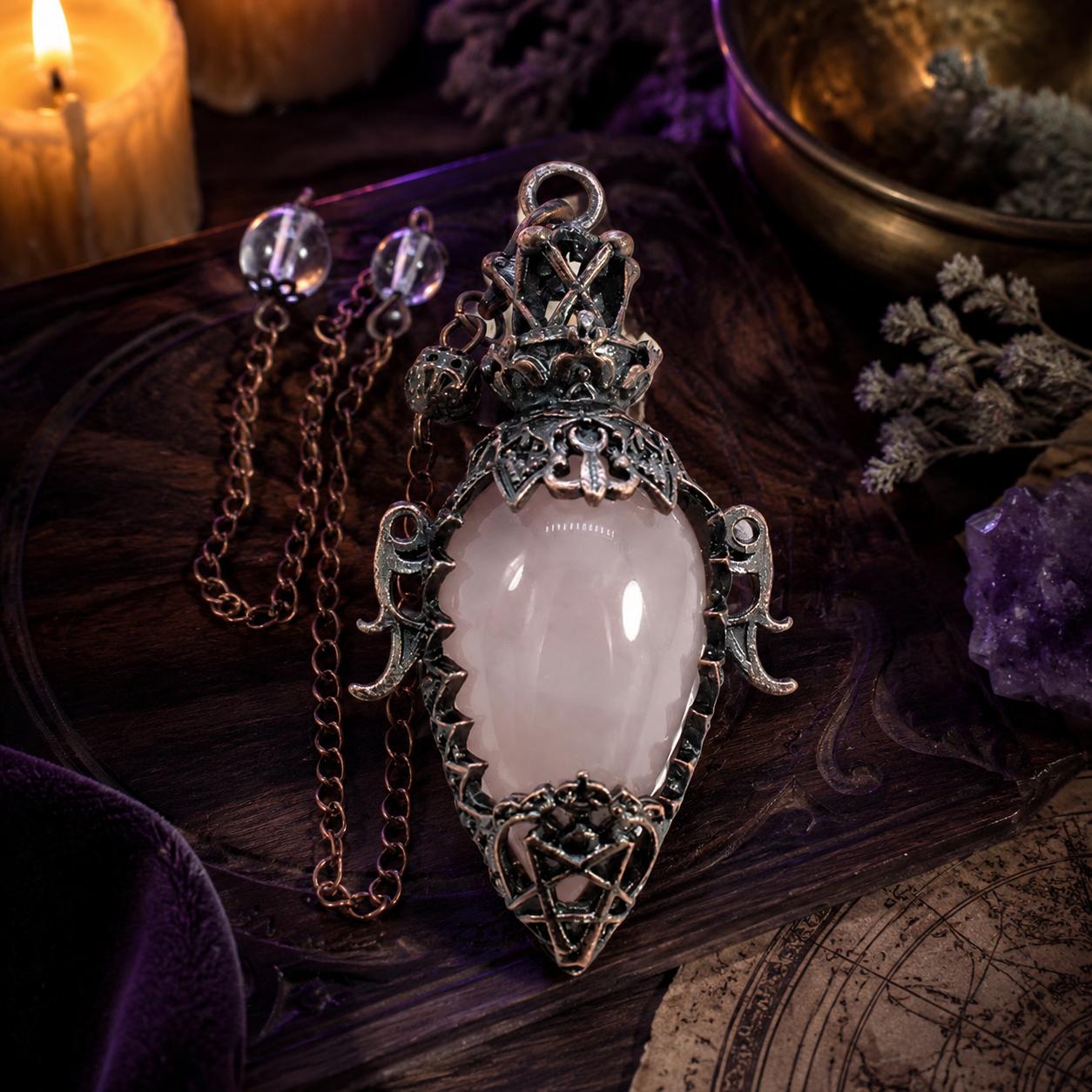 Rose quartz chain water drop crystal pendulum on a Pagan ritual altar