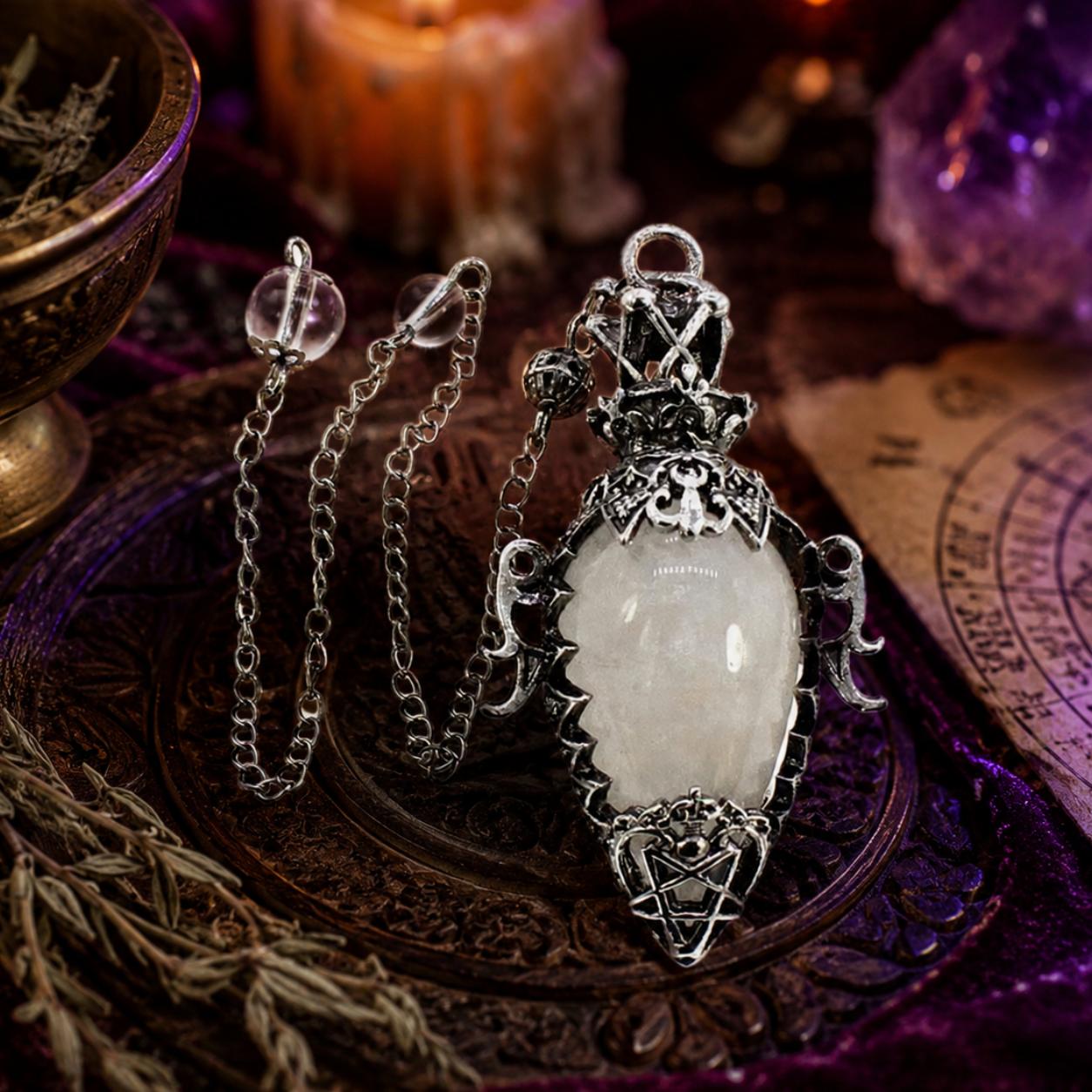 Clear chain 1 water drop crystal pendulum on a Pagan ritual altar