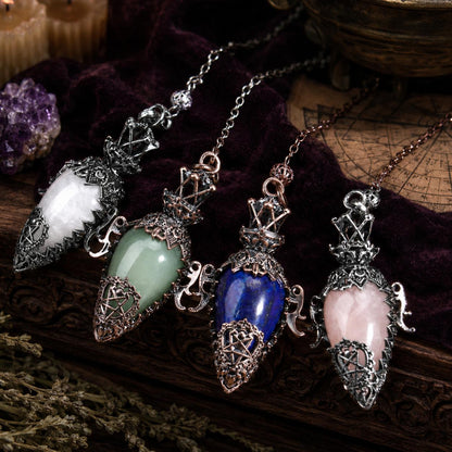 Antique water drop crystal pendulum collection on a Pagan ritual altar