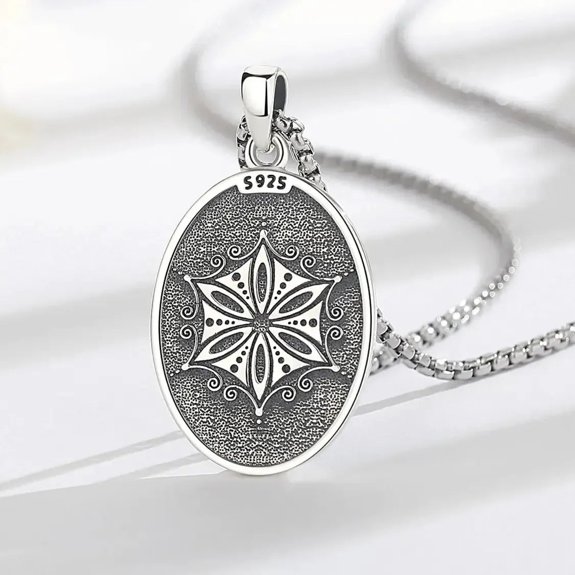 Patterned reverse of Aphrodite pendant on a wood surface