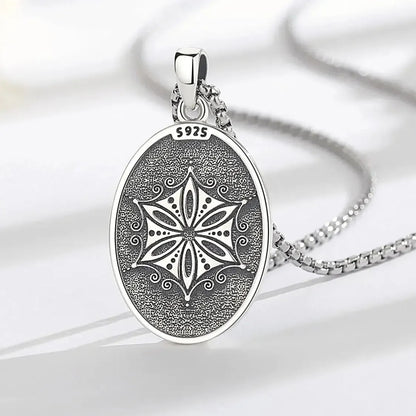 Patterned reverse of Aphrodite pendant on a wood surface