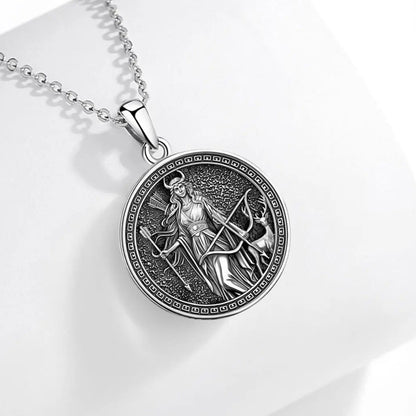 Front pendant on pale fabric: Artemis Goddess Necklace in 925 Sterling Silver, featuring Artemis with a bow and deer, framed in an antique-style round pendant.