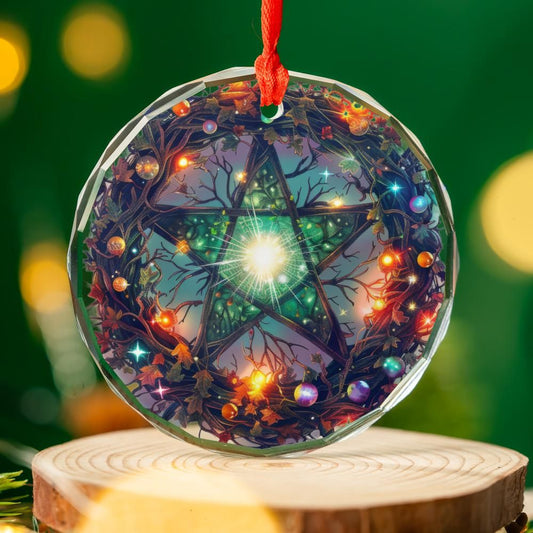 Clear glass pentagram ornament with colorful Yule tree and sparkling lights, hanging from a red ribbon.