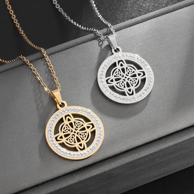 Gold and silver Celtic knot necklaces with clear crystal accents on a dark background.