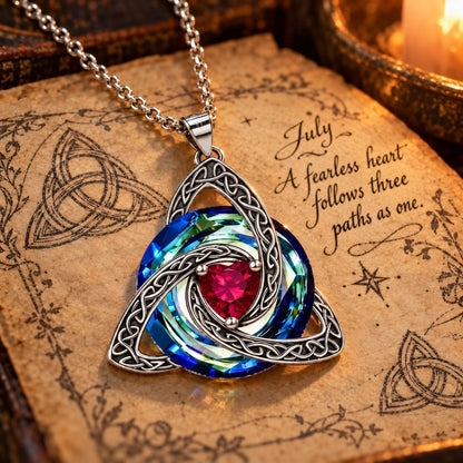 July Celtic Trinity Knot Birthstone Necklace on parchment — A fearless heart follows three paths as one.
