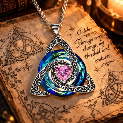 October Celtic Trinity Knot Birthstone Necklace on parchment — Through every change, my threefold bond endures.