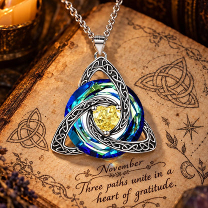 November Celtic Trinity Knot Birthstone Necklace on parchment — Three paths unite in a heart of gratitude.