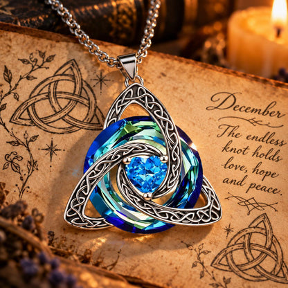 December Celtic Trinity Knot Birthstone Necklace on parchment — The endless knot holds love, hope and peace.