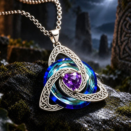 A silver Celtic knotwork pendant necklace with layered blue and green enamel rings and a central purple heart-shaped gemstone, resting on a mossy rock against a mystical night background with a full moon.