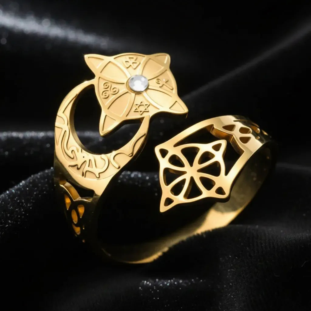 Gold Celtic knot crescent moon ring close-up, showing the engraved lunar band, star-shaped medallion set with a clear stone, and open quaternary knot cutout design.