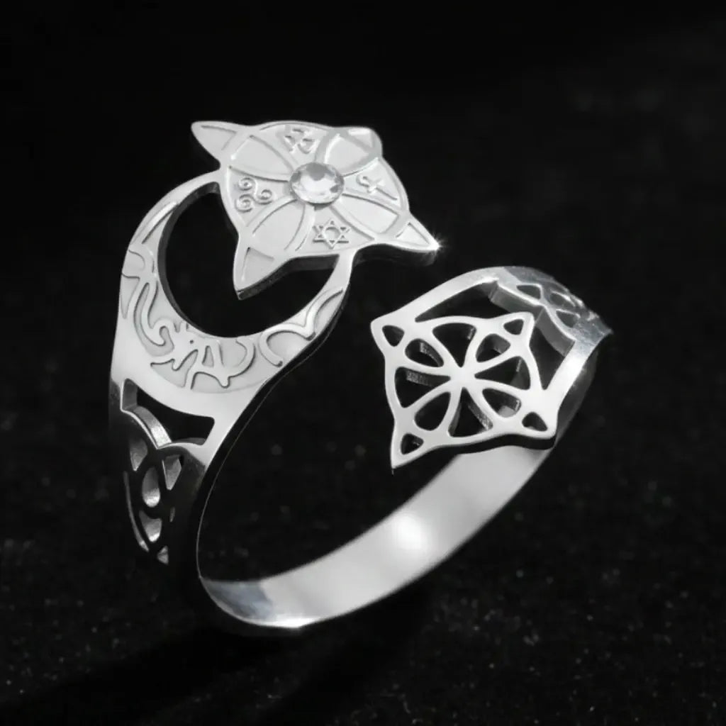 Silver Celtic knot crescent moon ring, showing the engraved lunar band, star-shaped medallion set with a clear stone, and open celtic knot cutout design.