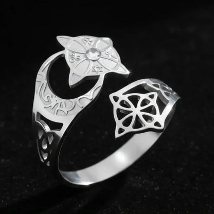 Silver Celtic knot crescent moon ring, showing the engraved lunar band, star-shaped medallion set with a clear stone, and open celtic knot cutout design.