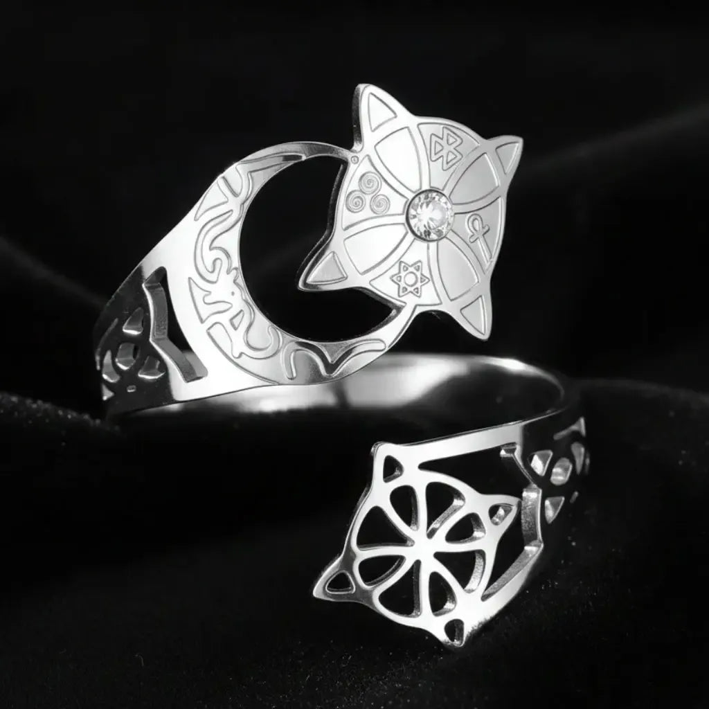 Silver Celtic knot crescent moon ring in an elevated top-down view, showing the engraved lunar band, star medallion with clear stone, and open celtic knot cutout on the adjustable open band.