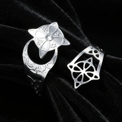 Silver crescent moon witch ring close-up on dark satin, showing the celtic knotwork cutout, engraved lunar band, and star medallion set with a clear stone.