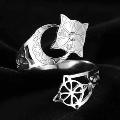 Silver Celtic knot crescent moon ring in an elevated top-down view, showing the engraved lunar band, star medallion with clear stone, and open celtic knot cutout on the adjustable open band.