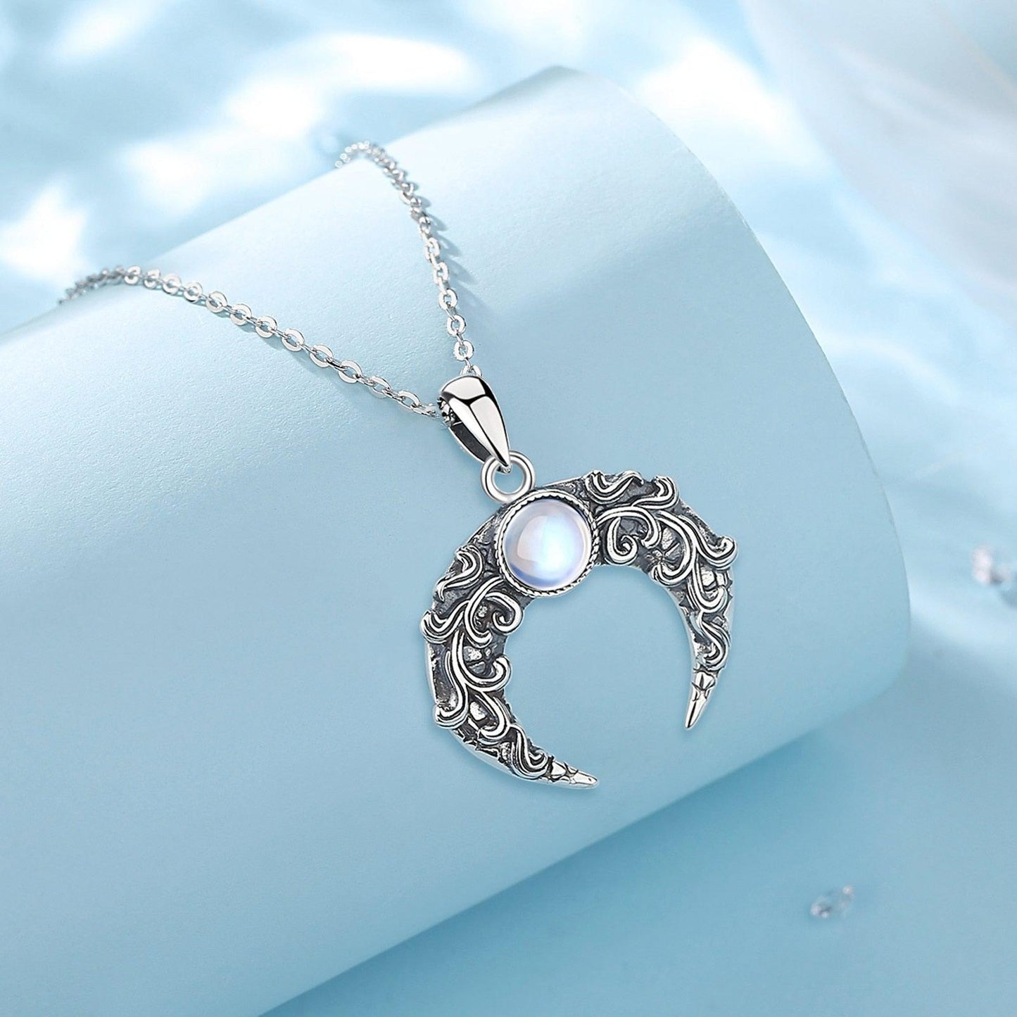 Exquisite 925 sterling silver Crescent Moon Necklace with a glowing moonstone and intricate filigree design.