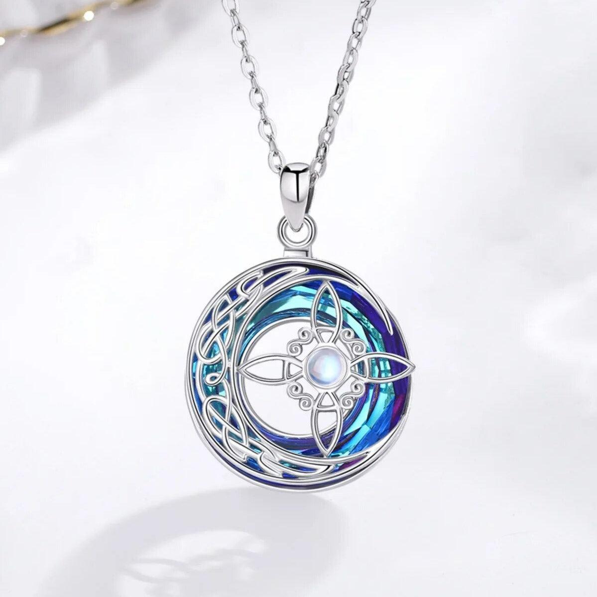 Sterling silver Witch Knot amulet with a crescent moon, blue crystal, and moonstone center.