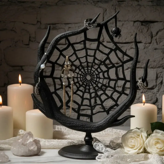 Spider web jewelry stand with earrings and makeup products on a neutral background