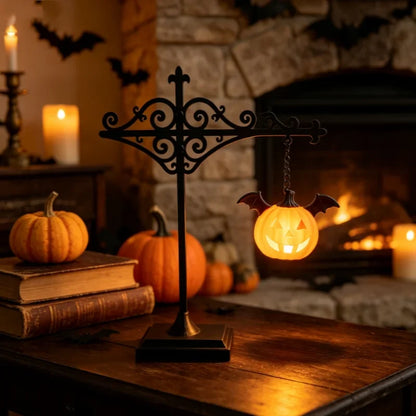 Halloween jack-o-lantern bat wing lantern glowing by fireplace with candles