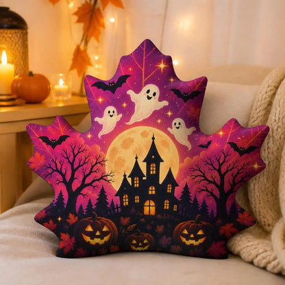 Styled room view: decorative plush pillow featuring maple leaf with ghost, haunted house and jack-o-lantern artwork