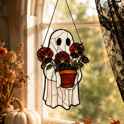 Cute ghost suncatcher hanging among houseplants in a window