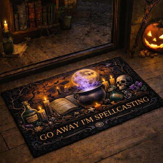 Black gothic doormat with "GO AWAY I'M SPELLCASTING" text, cauldron, skull, and candles.