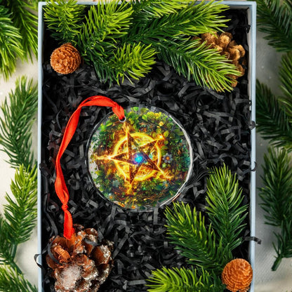 Clear glass pentagram ornament with glowing center, red ribbon, in a gift box with pine needles and cones.