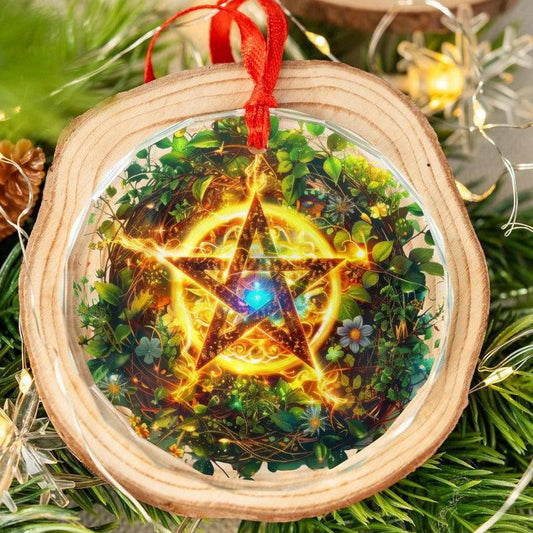 Clear glass pentagram ornament with a glowing star design, red ribbon, and wood slice frame on a Yule tree.