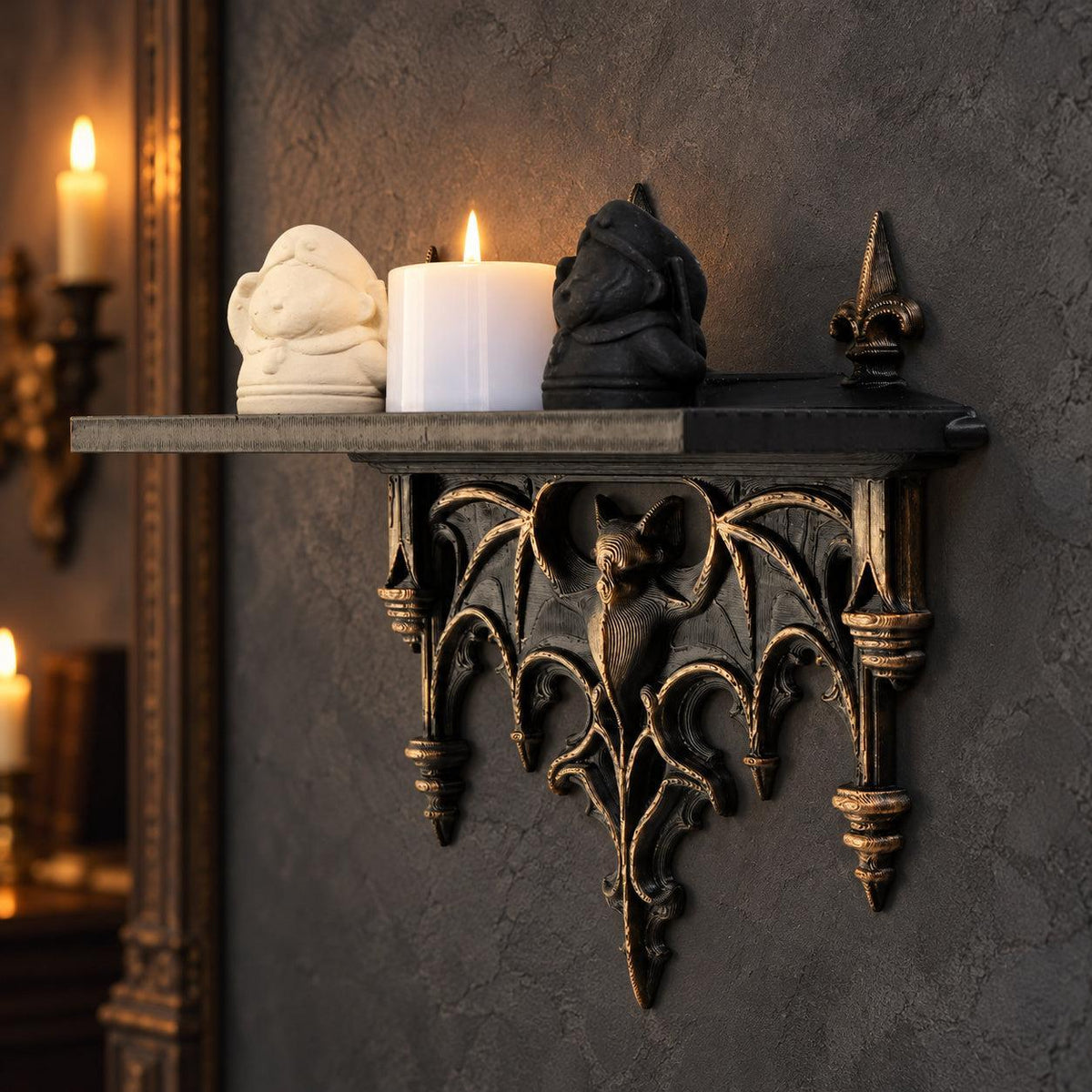 Side view of bat gargoyle shelf styled with figurines and a white candle