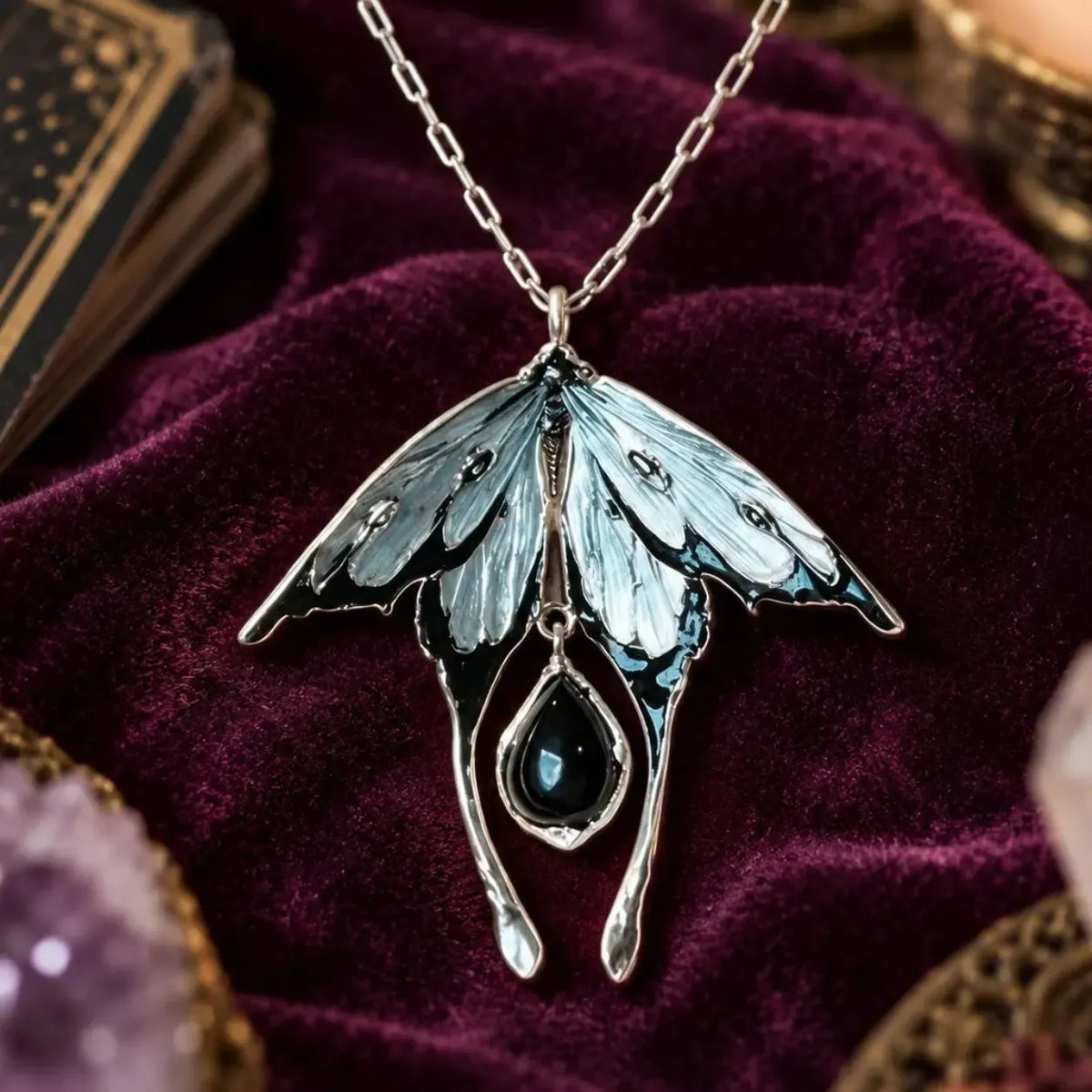 Moth pendant with silver-tone wings and black teardrop charm