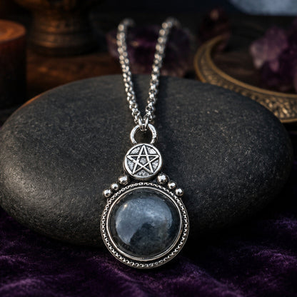 Round stone pentagram amulet necklace on moonlit Pagan altar