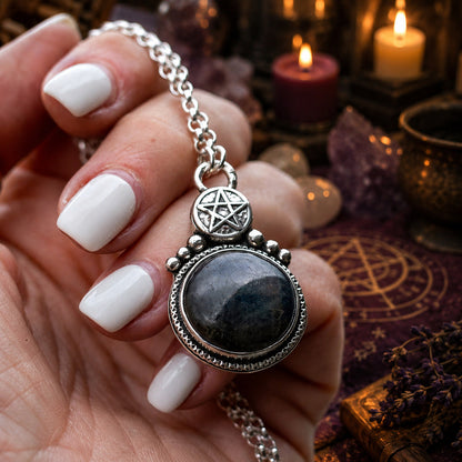 Hand holding Gothic pentagram necklace with round stone in Pagan altar scene