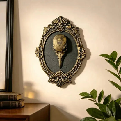 Styled interior display: Gothic Raven Skull Wall Plaque, featuring a raven skull relief surrounded by an elaborate oval frame.