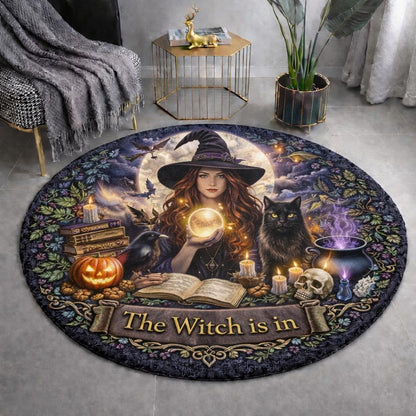 Gothic witch with black cat, raven, pumpkin, and cauldron on a round rug with "The Witch is in" text.