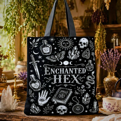 Enchanted Hex black tote bag with sun, skull, moth, crystals, snake, and Spells book illustrations